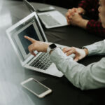 Ordinateur avec une personne montrant du doigt l'écran